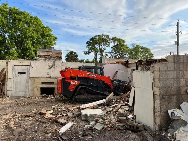 Track loader demolishing a concrete block building