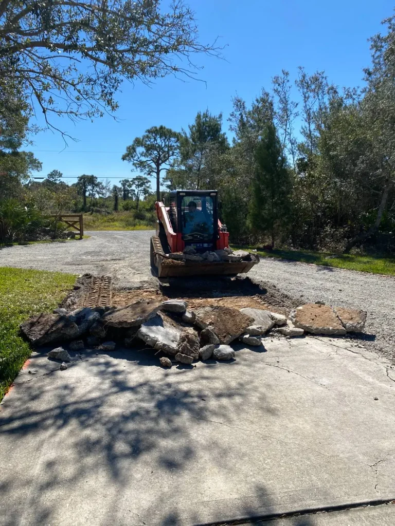 Track loader breaking up a concrete driveway