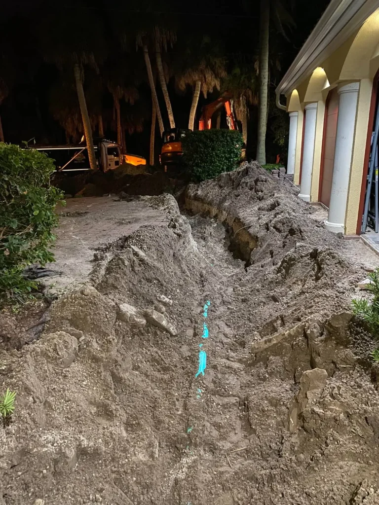 Trench with new pipe dug beside a home