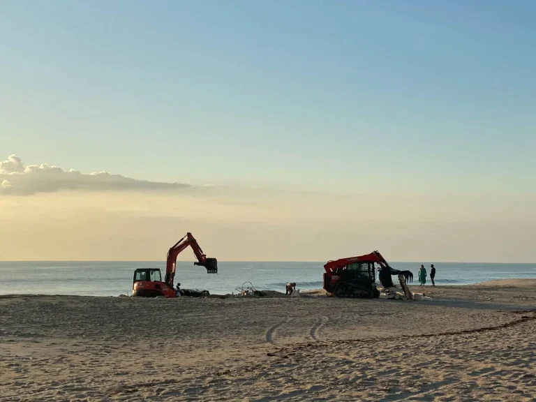 Excavator and track loader on the beach in the early morning