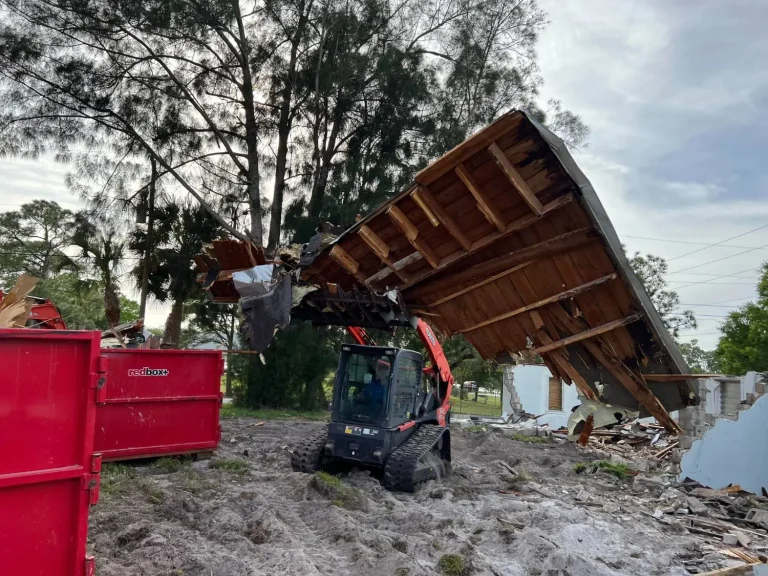 Track loader lifting a roof section during a demolition