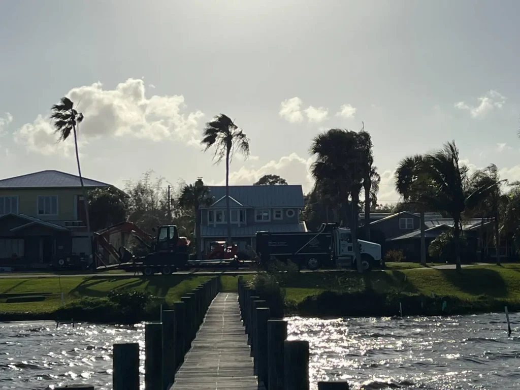 Dock and canal behind waterfront homes at sunset