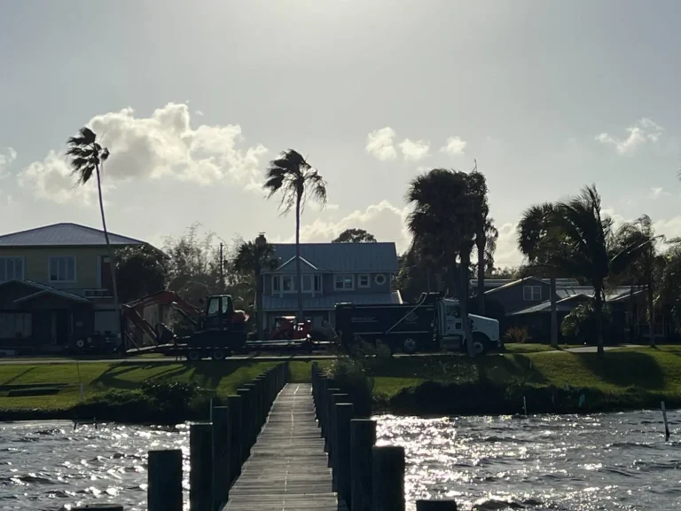 Dock and canal behind waterfront homes at sunset