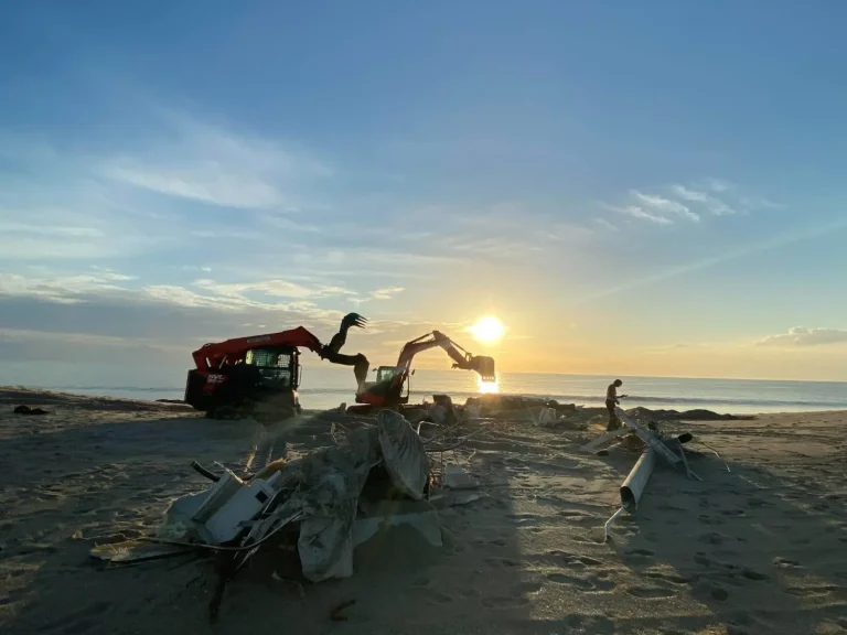 Sandy beach and a dune being shaped by an excavator