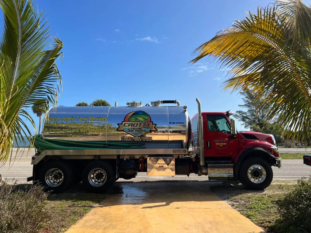 Red vacuum pump-out truck on a palm-lined street